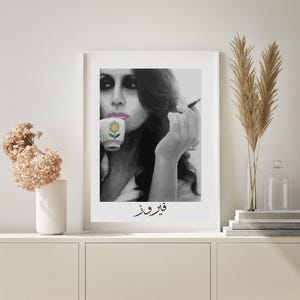 May include: Black and white portrait of a woman with dark hair, holding a cup with a flower design and a cigarette. The text "قلب و فز" is written below the image.