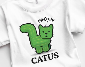 May include: White t-shirt featuring a green cactus cat illustration. The cat has a prickly green body and a black face with a surprised expression. The text "Me-Ouch!" is above the cat and "CATUS" is below the cat.