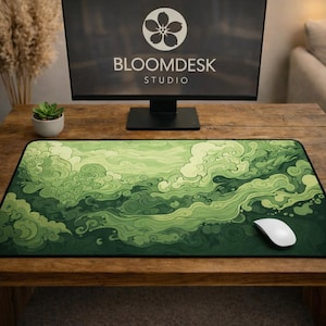 May include: A green mouse mat featuring a swirling cloud pattern. The mat sits on a wooden desk, with a computer monitor displaying the Bloomdesk Studio logo. A white mouse is positioned on the right side.