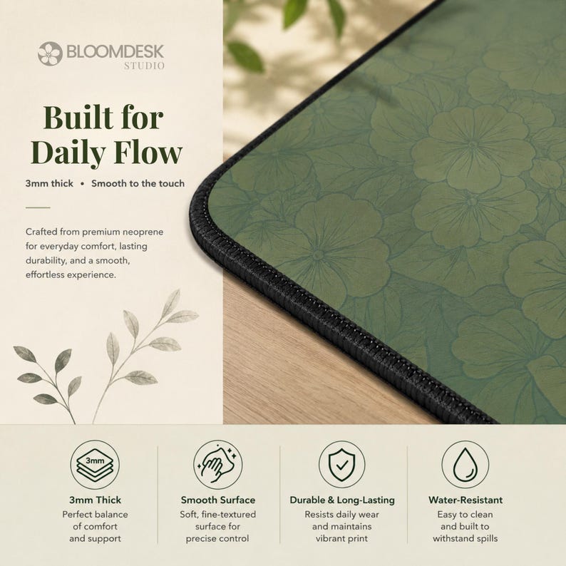 May include: A rectangular desk mat featuring a dark green surface with a repeating floral line art pattern and black stitched edges. The mat is 3mm thick and includes text stating Built for Daily Flow, 3mm thick, and Smooth to the touch.