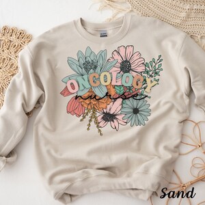 May include: A sand-colored sweatshirt with a floral design and the text "ONCOLOGY nurse" in colorful letters.