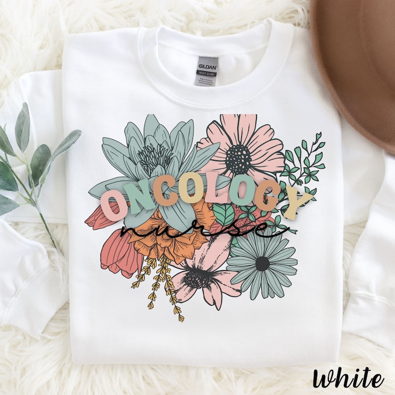May include: White sweatshirt with a floral design and the words "ONCOLOGY NURSE" in colorful letters.