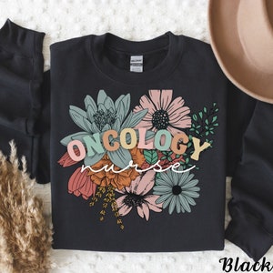 May include: Black sweatshirt with a floral design and the text "ONCOLOGY nurse" in colorful letters.