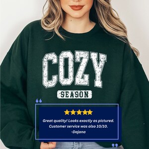 May include: A dark green sweatshirt with a white distressed graphic that says "COZY SEASON".