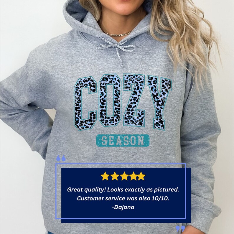 May include: Grey hooded sweatshirt with a blue and white leopard print graphic that says "COZY SEASON".