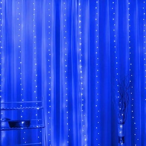May include: Blue LED curtain lights strung across a blue curtain. The lights are spaced evenly and create a twinkling effect.