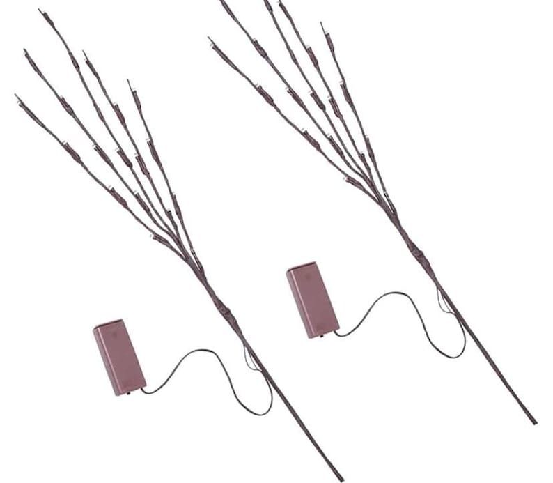 May include: Two sets of battery-powered twig lights with brown branches and white LED lights. Each set has a brown battery pack with a wire connecting to the lights.