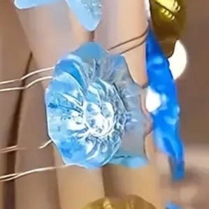 May include: A string of decorative lights featuring seashell and starfish shapes. The lights are in shades of blue and gold, with a warm glow. The string lights are ideal for beach-themed decor.