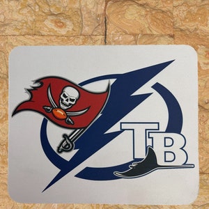 May include: A white square with a blue and red logo. The logo features a lightning bolt, a pirate skull and crossbones, and the letters "TB".