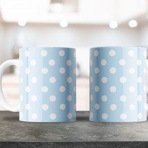 May include: Two light blue ceramic mugs with white polka dots. The mugs have white handles.