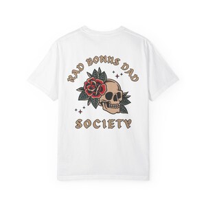 May include: White t-shirt with a skull and rose graphic and the text "Rad Bonus Dad Society" printed on the back.