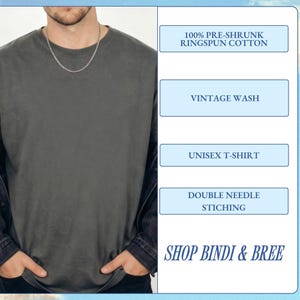 May include: A dark gray unisex t-shirt made of 100% pre-shrunk ringspun cotton. The shirt has a vintage wash and double needle stitching. The text "SHOP BINDI & BREE" is displayed at the bottom.
