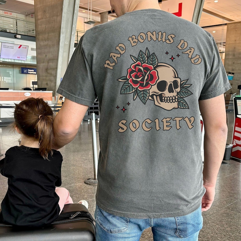 May include: A gray t-shirt with a skull and rose graphic and the text "Rad Bonus Dad Society".
