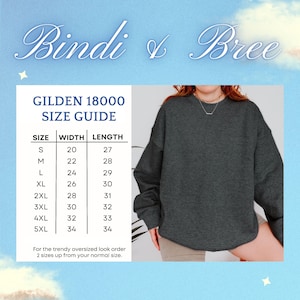 May include: Size chart for Gildan 18000 sweatshirts, showing width and length measurements in inches for sizes S through 5XL. The chart is printed on a white background with a blue and white cloud pattern. The text "Bindi & Bree" is printed in a cursive font at the top of the chart.