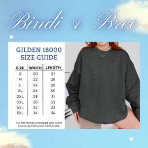 Pode incluir: Tabela de tamanhos para sweatshirts Gildan 18000, mostrando as medidas de largura e comprimento em polegadas para os tamanhos S a 5XL. A tabela &eacute; impressa em um fundo branco com um padr&atilde;o de nuvens azuis e brancas. O texto "Bindi & Bree" &eacute; impresso em uma fonte cursiva no topo da tabela.