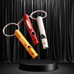 May include: Three personalized keychains in gold, red, and silver, each with a whistle design. The gold keychain is inscribed with "Michael", the red with "HEAT AND CENTER", and the silver with "Andrew". The keychains are displayed on a black pedestal against a black backdrop.