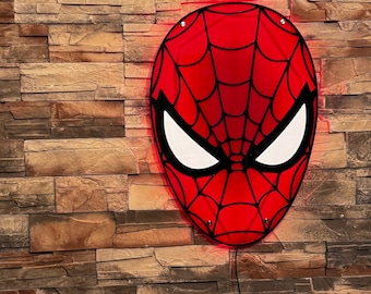 May include: A red and black Spider-Man mask wall light with a white eye design. The light is mounted on a brick wall.