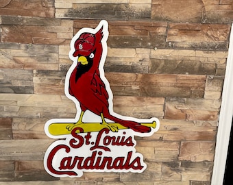 May include: A red cardinal wearing a baseball cap with the letter "B" on it, holding a yellow baseball bat with the words "St. Louis Cardinals" in white lettering.