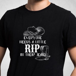 May include: Black t-shirt with a white graphic of a cowboy hat and boot with the text "Everyone needs a little RIP in their jeans".