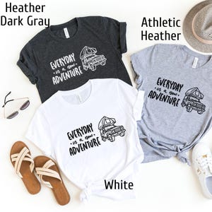 May include: Three t-shirts in different colors: white, dark gray, and athletic heather. Each shirt features a black and white graphic of a camper van with the text "EVERYDAY is a new ADVENTURE".