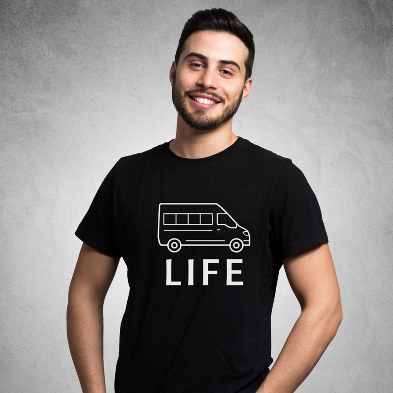 Op de afbeelding: Een zwart T-shirt met een witte omtrek van een bestelwagen en het woord "LIFE" gedrukt op de voorkant.