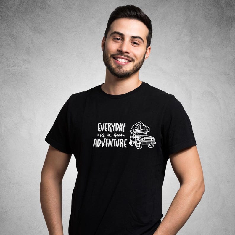 Może przedstawiać: Czarny t-shirt z białym nadrukiem przedstawiającym kampera z napisem "EVERYDAY is a new ADVENTURE".
