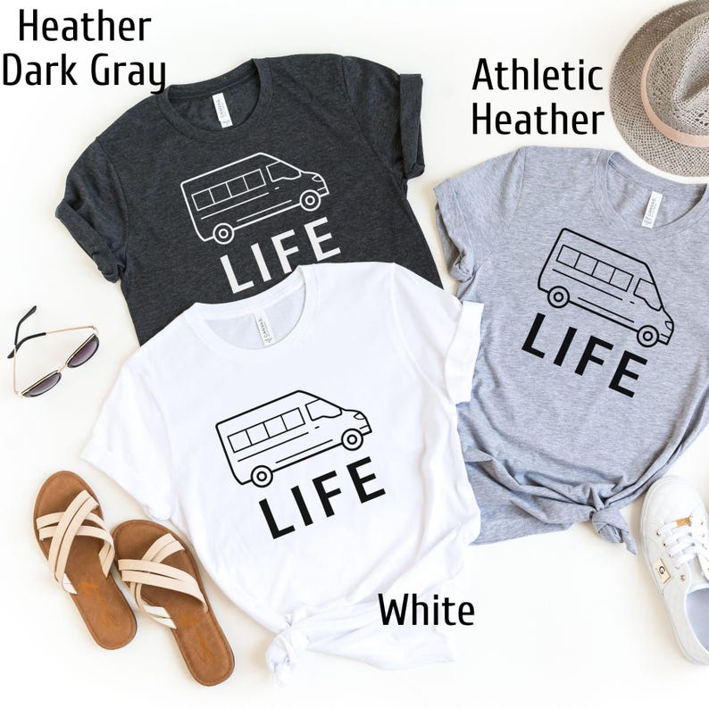 Op de afbeelding: Drie T-shirts met een afbeelding van een busje en het woord "LIFE" erop gedrukt. De T-shirts zijn in wit, donkergrijs melange en sportgrijs melange.