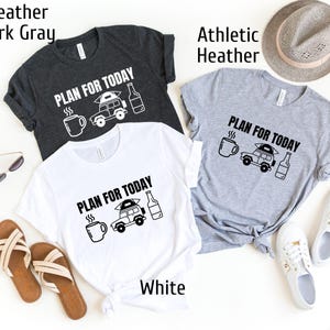 Puede incluir: Tres camisetas en gris oscuro, blanco y gris jaspeado deportivo. Cada camiseta presenta la frase "PLAN FOR TODAY" con un gr&aacute;fico de una taza de caf&eacute;, una furgoneta camper y una botella. La camiseta blanca est&aacute; etiquetada como "White".