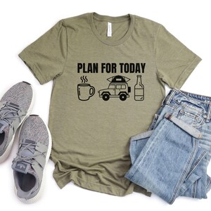 May include: A green t-shirt with the text "PLAN FOR TODAY" printed on it. The text is accompanied by a graphic of a coffee cup, a car with a tent on top, and a bottle of beer.