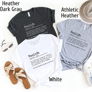 Puede incluir: Tres camisetas de diferentes colores: gris oscuro, gris deportivo y blanco. Cada camiseta presenta un dise&ntilde;o gr&aacute;fico con la palabra "Vanlife" definida como un "estilo de vida minimalista autosuficiente centrado en viajar en una furgoneta a voluntad para perseguir pasiones personales y una vida sin estructura de libertad."
