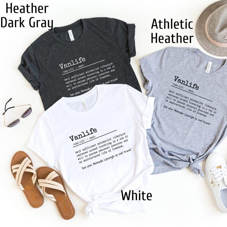 Puede incluir: Tres camisetas de diferentes colores: gris oscuro, gris deportivo y blanco. Cada camiseta presenta un dise&ntilde;o gr&aacute;fico con la palabra "Vanlife" definida como un "estilo de vida minimalista autosuficiente centrado en viajar en una furgoneta a voluntad para perseguir pasiones personales y una vida sin estructura de libertad."
