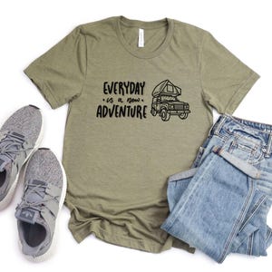 Może przedstawiać: Zielony T-shirt z napisem "EVERYDAY is a new ADVENTURE" i czarno-białą ilustracją kampera.