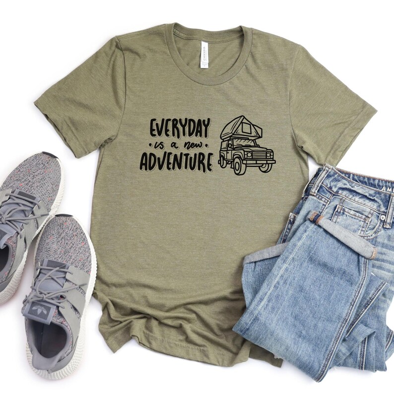 Może przedstawiać: Zielony T-shirt z napisem "EVERYDAY is a new ADVENTURE" i czarno-białą ilustracją kampera.