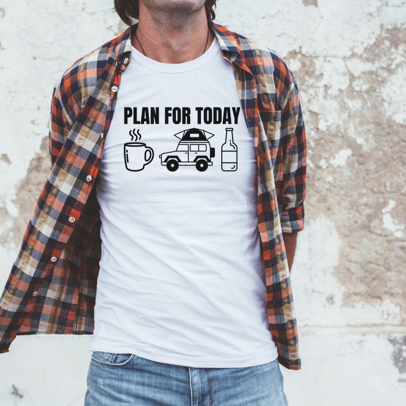 Puede incluir: Camiseta blanca con el texto "PLAN FOR TODAY" encima de una taza de caf&eacute;, un veh&iacute;culo de camping y una botella. La persona lleva una camisa a cuadros sobre la camiseta.