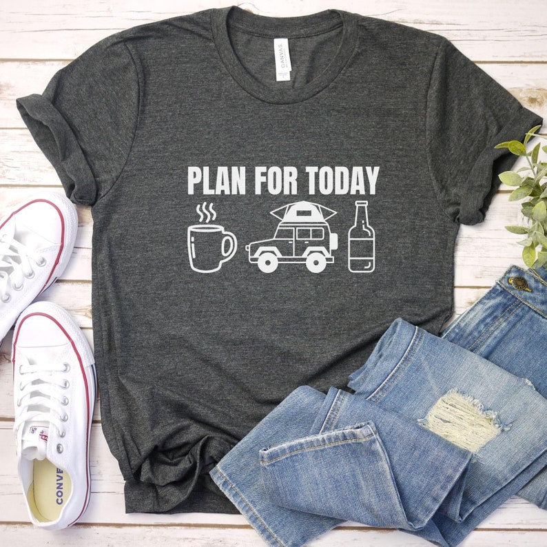 May include: A dark gray t-shirt with the text "PLAN FOR TODAY" in white. The shirt features a white illustration of a coffee mug, a car with a tent on top, and a bottle of beer.