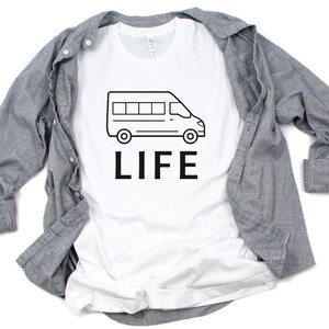 Op de afbeelding: Wit T-shirt met een zwarte omtrek van een bestelwagen en het woord "LIFE" erop gedrukt.