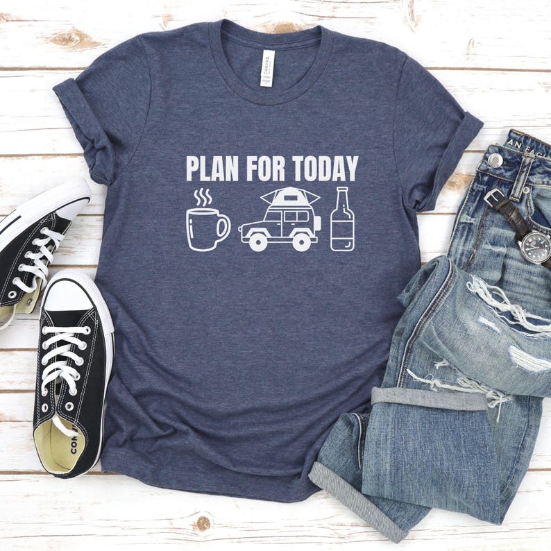 May include: A navy blue t-shirt with the text "PLAN FOR TODAY" in white. The shirt features a white illustration of a coffee cup, a jeep with a tent on top, and a bottle of beer.