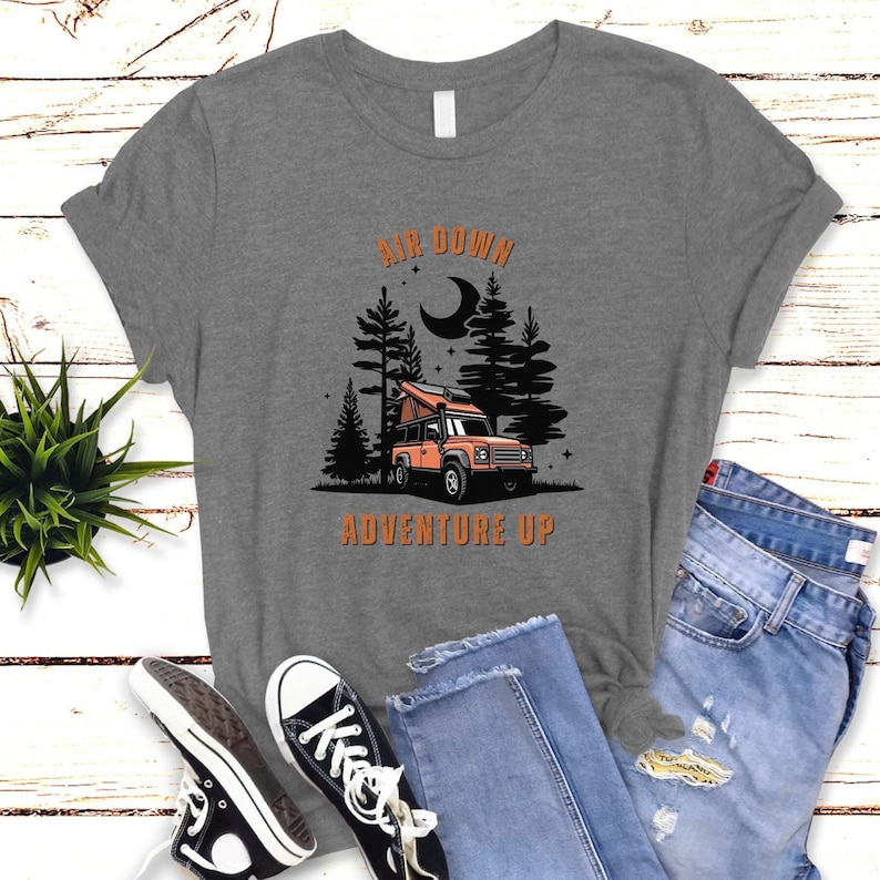 May include: Grey t-shirt with a graphic of a camper van in a forest with the text "Air Down Adventure Up".