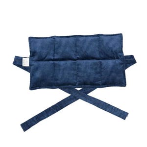 May include: A navy blue, corduroy-textured wrap with a rectangular padded centre and long, cross-over straps. The wrap has a label attached to one side. The product is designed to be worn around the body.