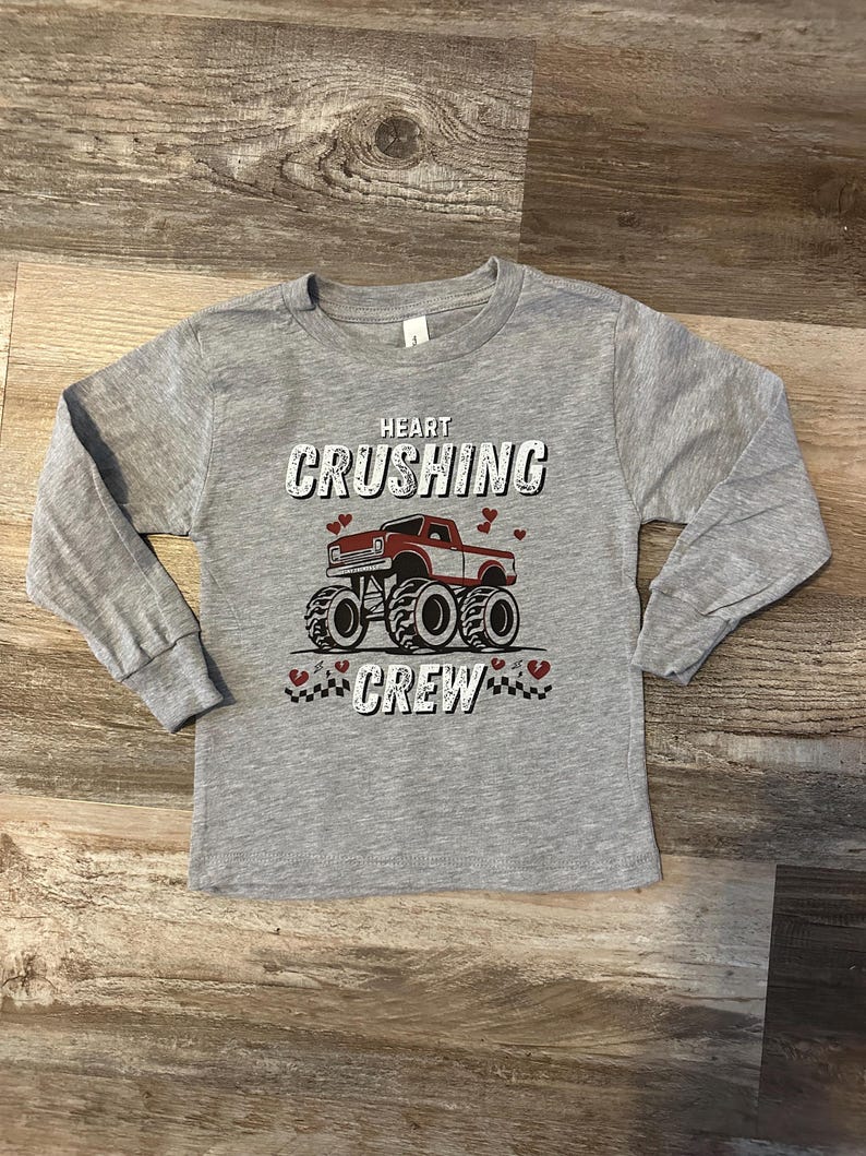 May include: Gray long-sleeve shirt with a red truck graphic and the text "Heart Crushing Crew".