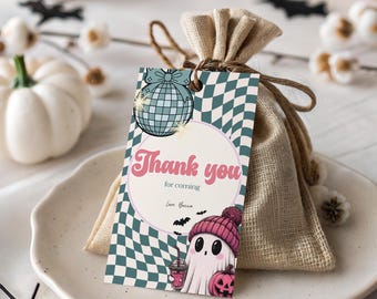 May include: A small burlap gift bag with a tag that says "Thank you for coming." The tag has a disco ball illustration and a cute ghost wearing a pink beanie and holding a pumpkin. The bag is on a white plate with pumpkins in the background.