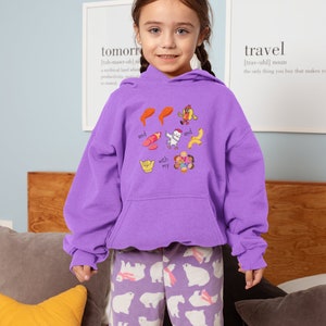 May include: A young person wearing a purple hoodie with a graphic print of food and the text "and with my and". The person is also wearing purple pants with a white polar bear pattern.