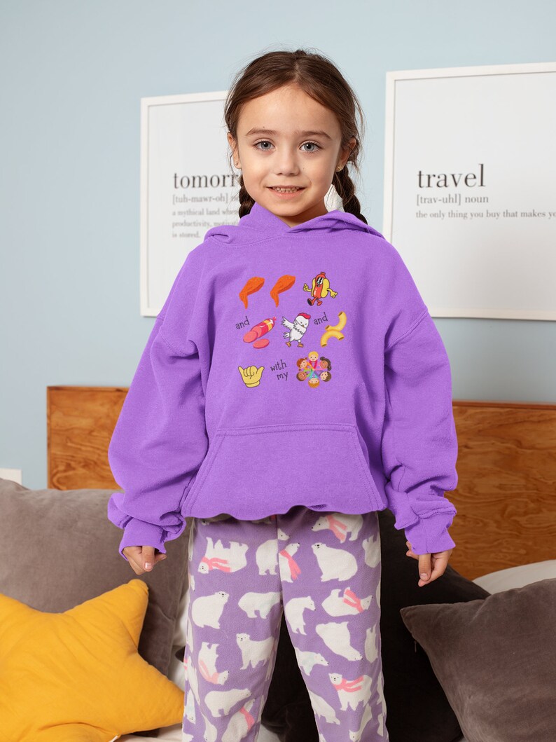 May include: A young person wearing a purple hoodie with a graphic print of food and the text "and with my and". The person is also wearing purple pants with a white polar bear pattern.