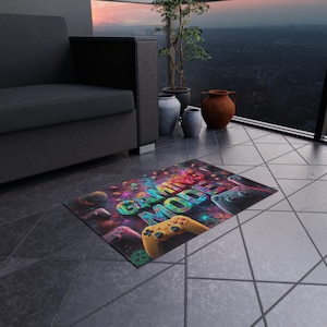 Puede incluir: Alfombra rectangular con temática de videojuegos. La alfombra muestra las palabras "GAMING MODE" en letras 3D, rodeadas de mandos de juego y formas abstractas. Un mando de juego amarillo se muestra de forma destacada.