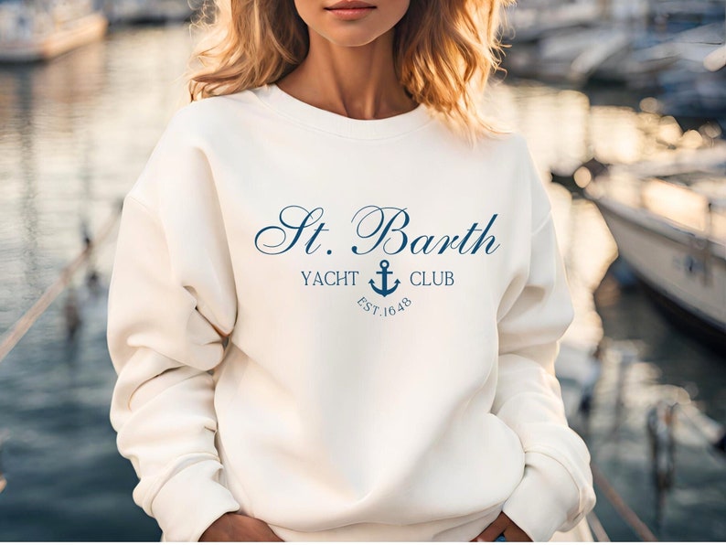 May include: White sweatshirt with a navy blue logo that says "St. Barth Yacht Club Est. 1648" with an anchor symbol.