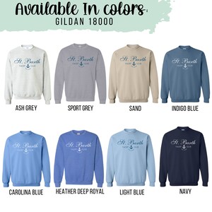 May include: A Gildan 18000 sweatshirt is shown in ten different colors: ash grey, sport grey, sand, indigo blue, carolina blue, heather deep royal, light blue, navy, black, and white. The sweatshirt has a logo that says "St. Barth Yacht Club" with an anchor symbol.