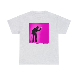 Pode incluir: Uma camiseta cinza com um gráfico quadrado rosa de uma silhueta de uma pessoa usando um chapéu e ouvindo um iPod Classic. O texto "iPod Classic" está abaixo do gráfico.