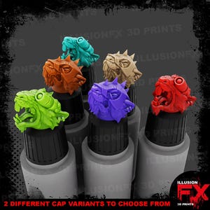 May include: A collection of six miniature animal-themed bottle caps in bright colours including lime green, teal, orange, tan, purple, and red. Each cap features a sculpted creature head with open mouths and detailed facial features, mounted on black lids.