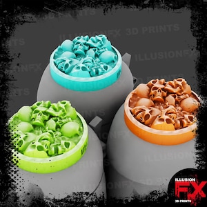 Puede incluir: Tres bases de juego circulares con una pila detallada de calaveras en la superficie superior. Una base es azul claro, otra verde brillante y otra naranja. El texto ILLUSIONFX 3D PRINTS es visible al fondo y en la esquina inferior derecha.