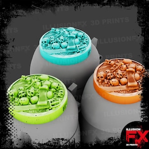 Puede incluir: Tres bases circulares para miniaturas con un montón detallado de calaveras, huesos y una espada. Una base es azul claro, otra verde lima y la tercera marrón. Cada base tiene una superficie texturizada con restos esqueléticos y un arma.